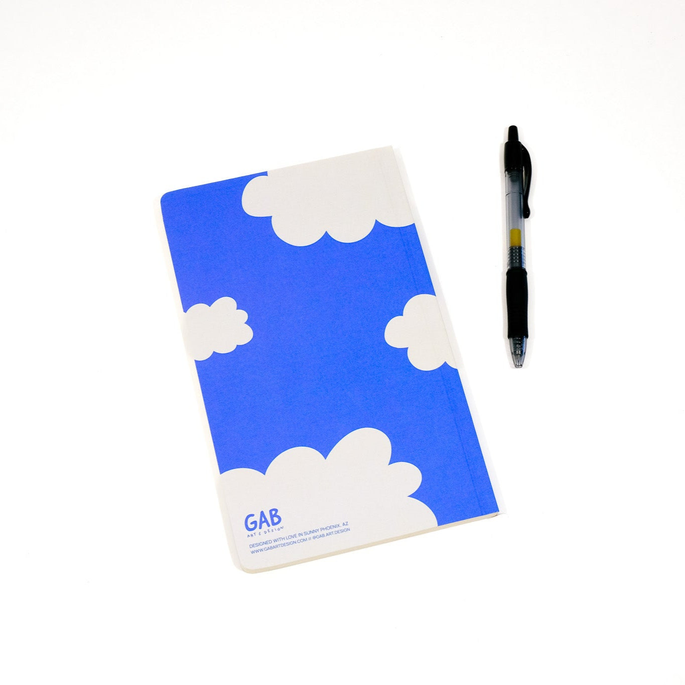 Blue notebook with cloud design and a pen on a white background