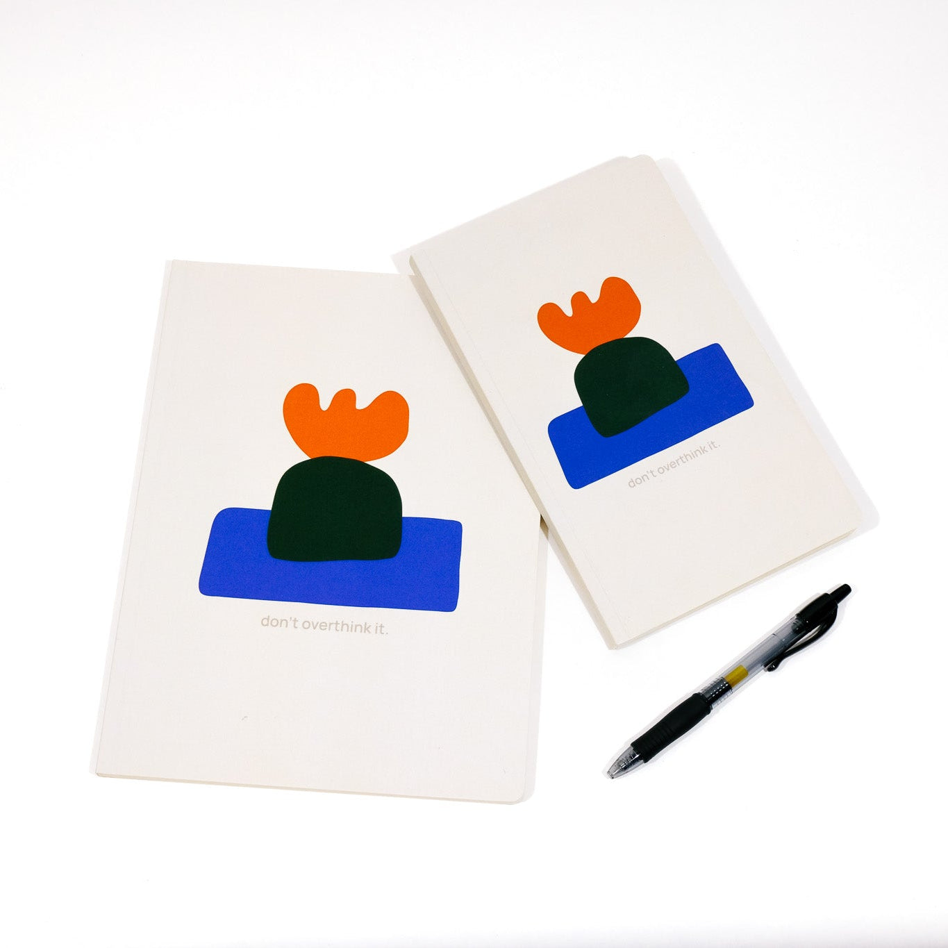 Two notebooks with colorful cactus designs on a white background, accompanied by a pen.