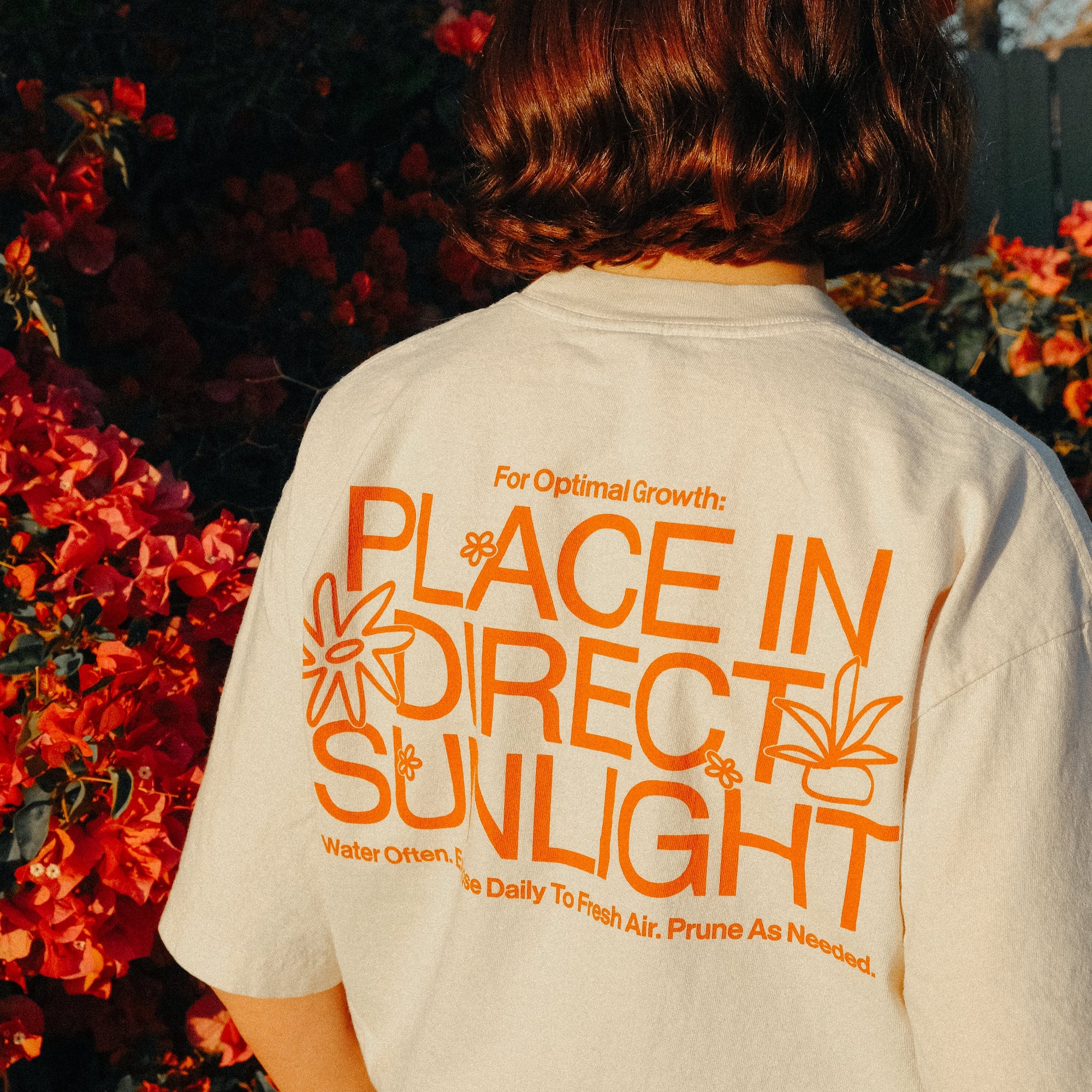 Person wearing a shirt with text in an outdoor setting